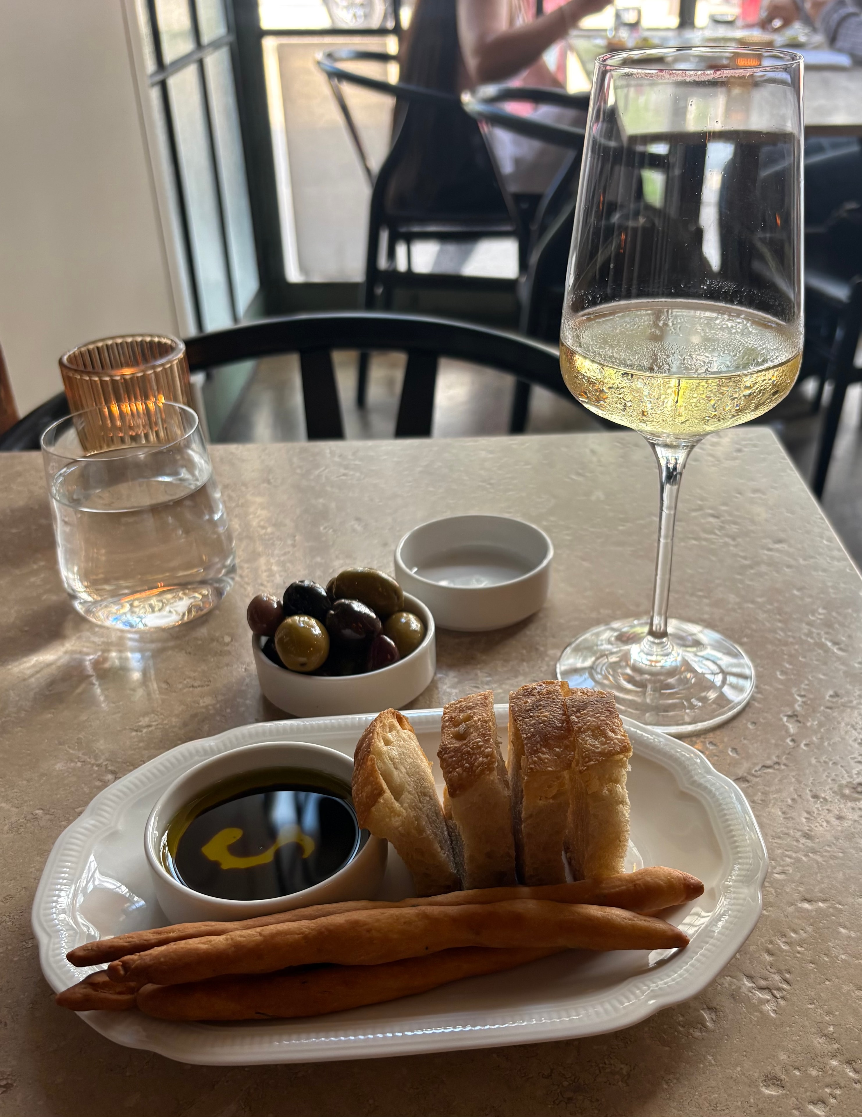 Table setting at Liliana — wine, bread, olives